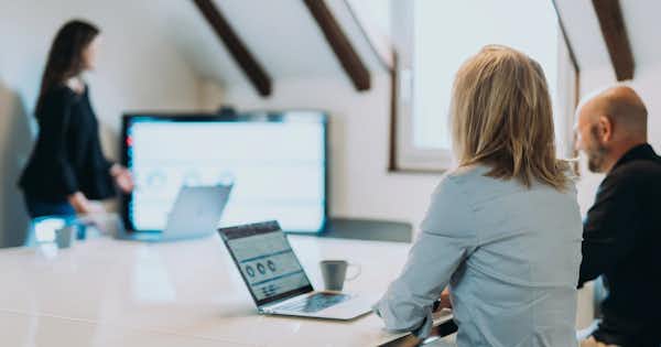Woman presenting to others seated at a table