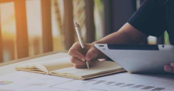 Someone writing in a ledger