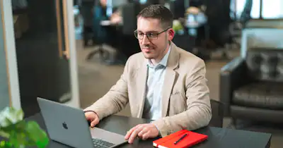 A man sitting at a desk, working on a la