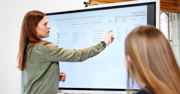 A woman drawing on a whiteboard.