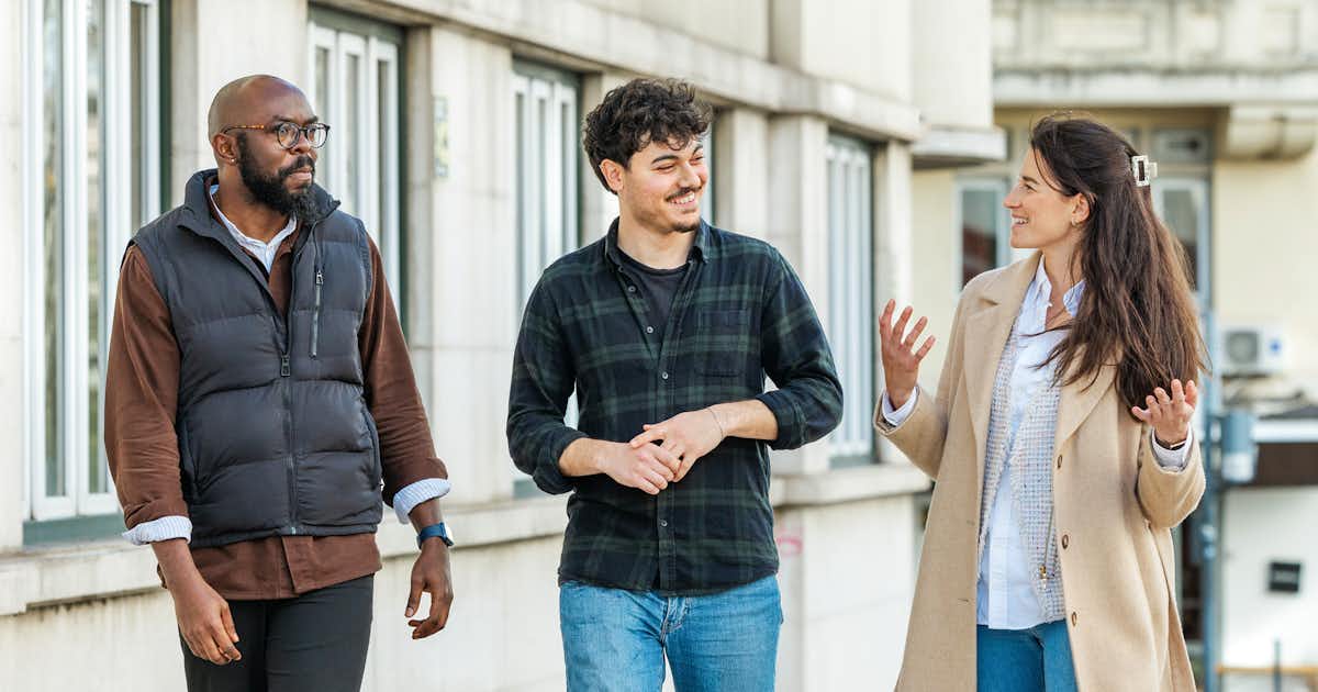 Three people talking in the street.