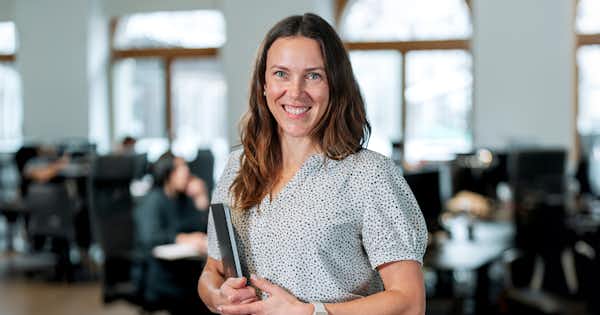 A photo of a woman in a bright office.