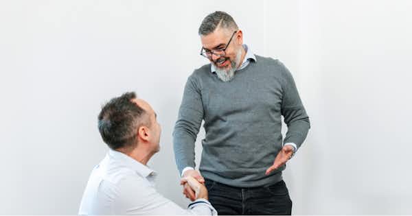 Two male employees shaking hands