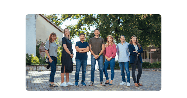 Group of women and men standing together outside.
