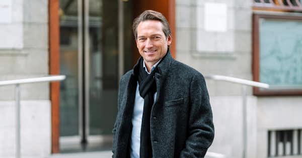 Man with jacket standing outside an office