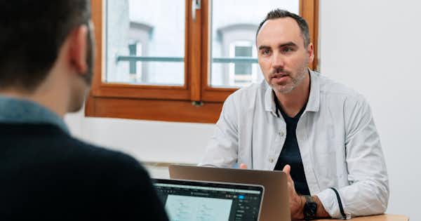 Two employees talking across a desk