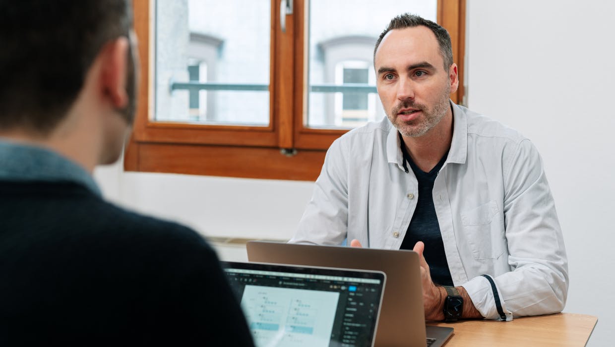 Deux employés discutant sur un bureau