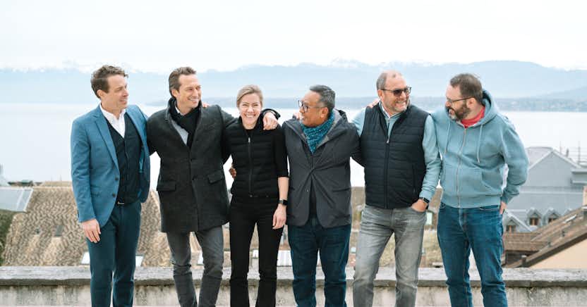 Groupe de personnes en plein air devant un lac.