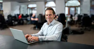 Man at desk with laptop.