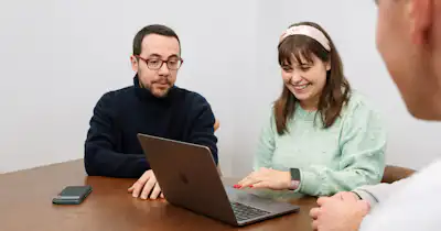 People in a meeting in front of a computer.