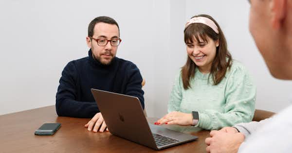 Two people looking at a laptop screen.
