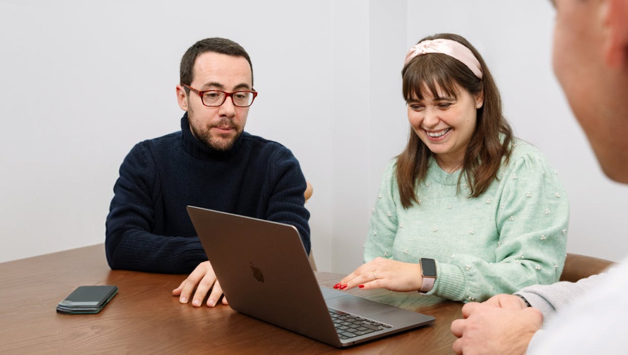 Des personnes en réunion devant un ordinateur.