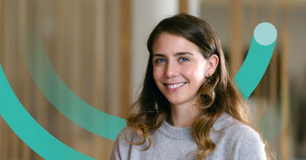 Woman smiling and a half circle graphic device behind her.