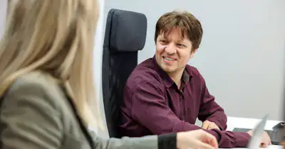 A man talking to a woman at work.