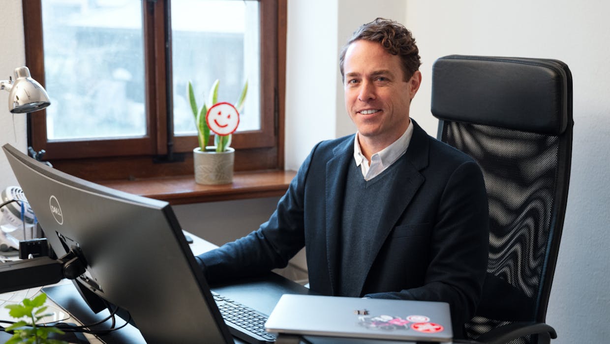 Homme assis dans un bureau et souriant