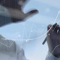 Homme penché sur un tableau où sont inscrits des chiffres