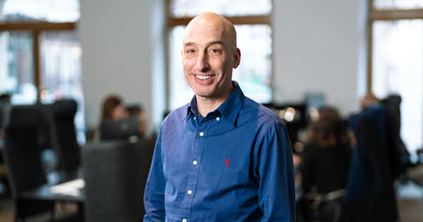 Man smiling in an office setting.