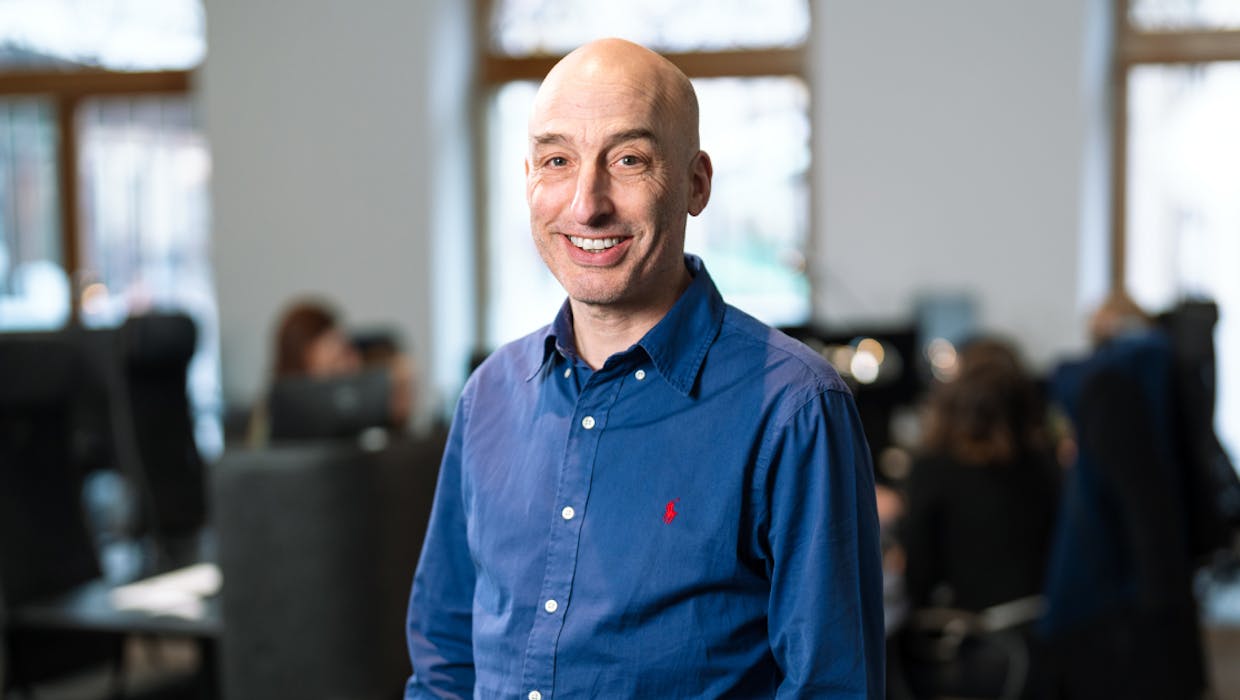 Un homme souriant dans un bureau.