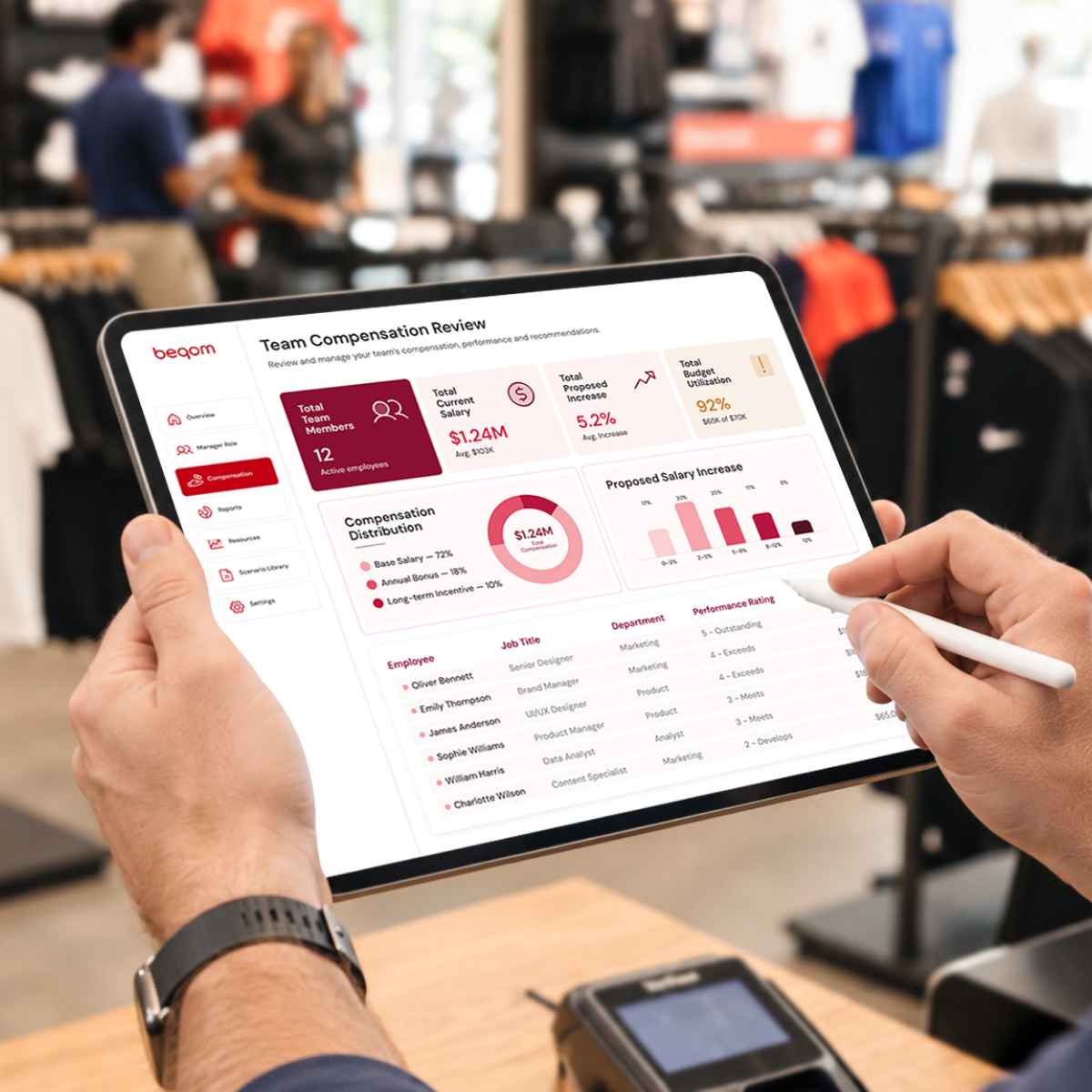 a person holding an ipad working on their team compensation review dashboard 