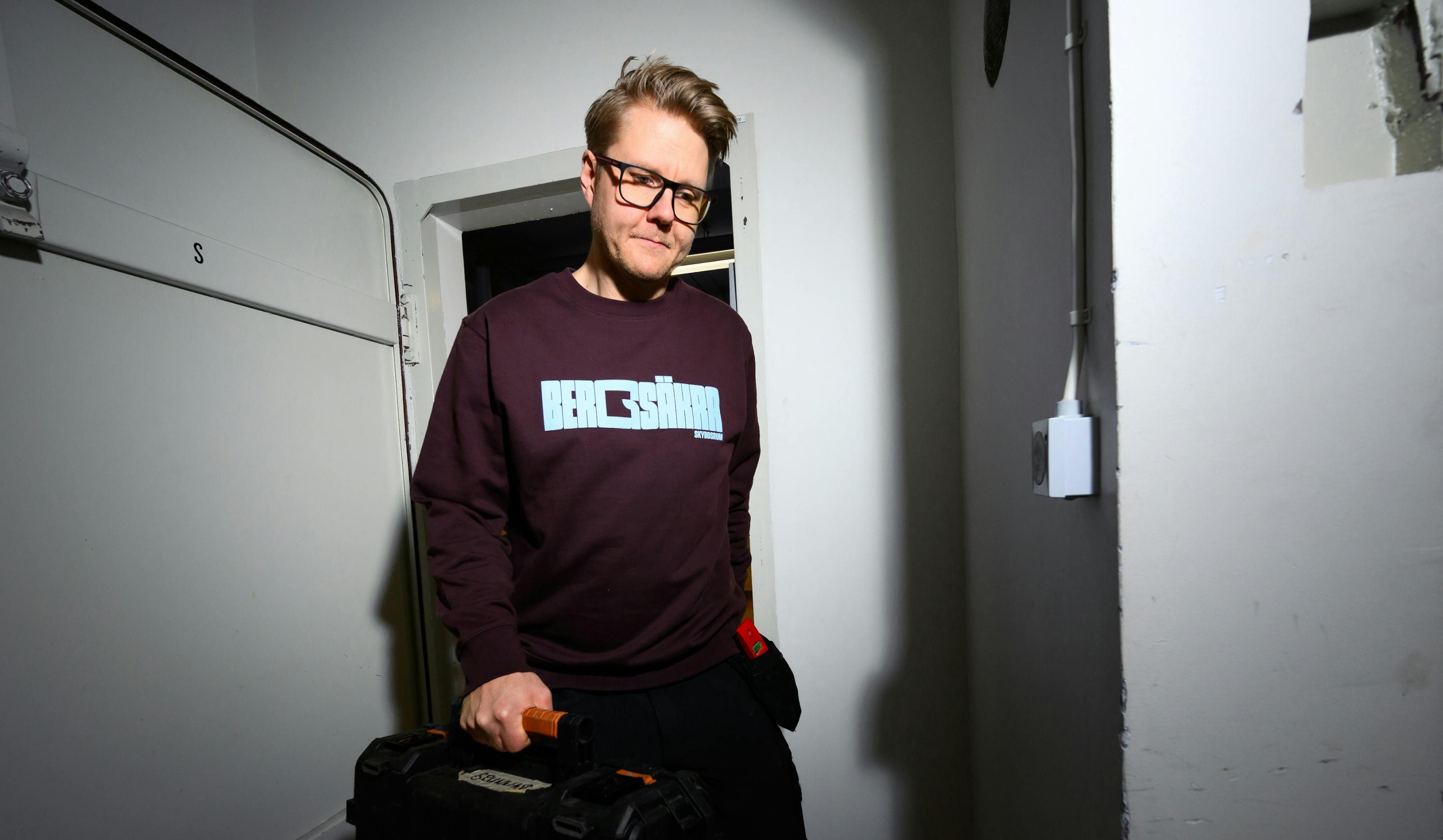 Skyddsrumsarbetare på väg ut ut skyddsrum med verktyg