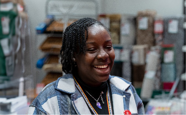 A person in a stock room smiling