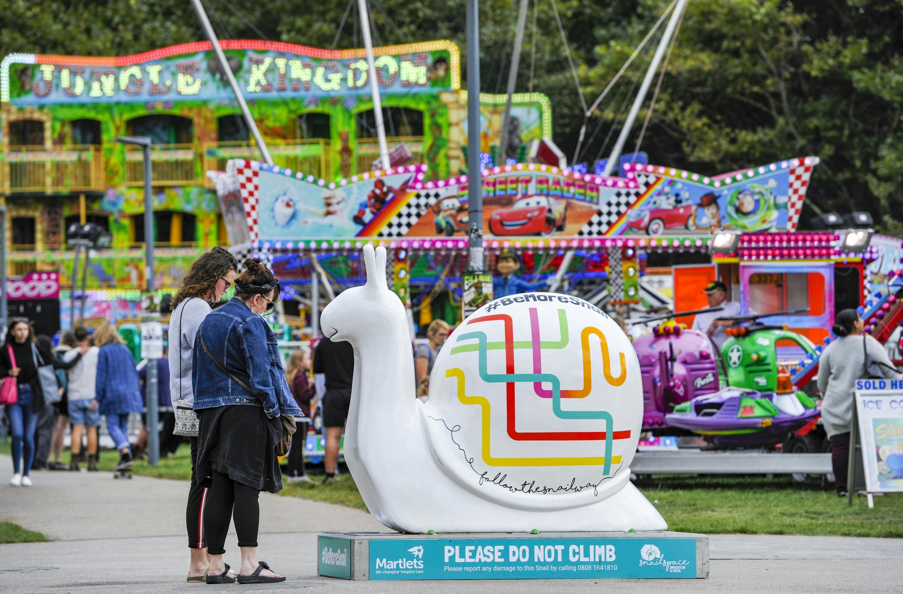 People looking at large Snail sculpture
