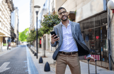 smiling man walking on the street with phone