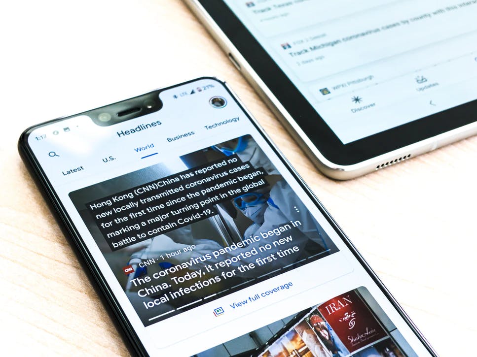 Phone displaying news app, showing news headlines