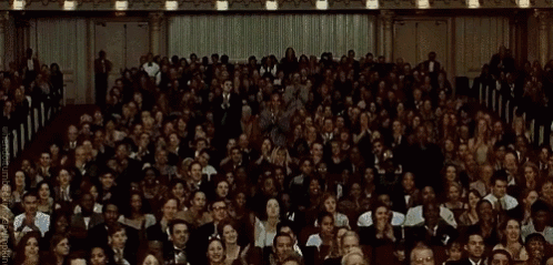 The crowd standing up for applause in a theatre