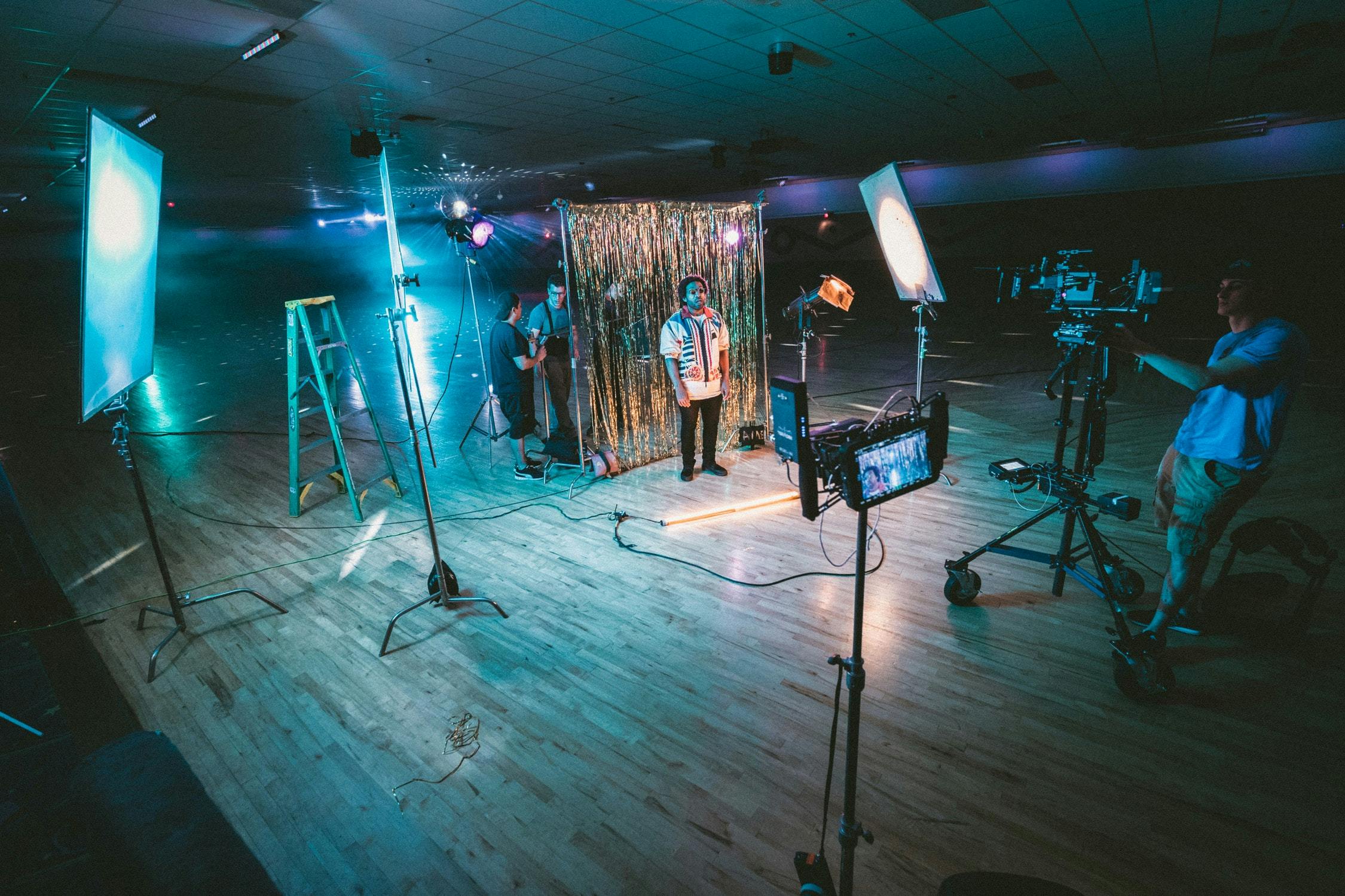 Behind the scenes of a photoshoot with a sparkly backdrop in a spacious studio