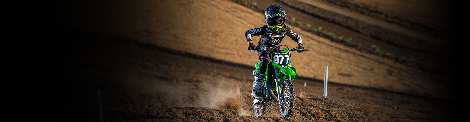 Kawasaki KX65 in lime green colour, in action on off road track