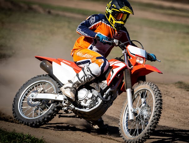 Honda CRF250F in extreme red colour being ridden on off road track