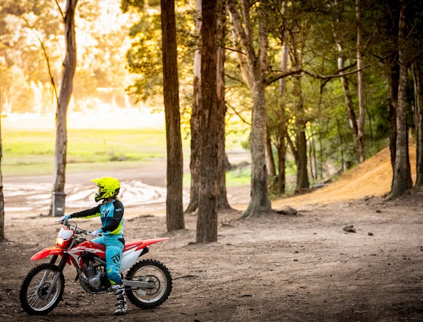 Honda CRF250F in extreme red colour being ridden on off road track
