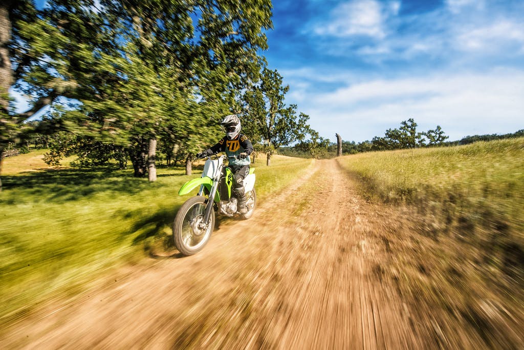 Kawasaki KLX300R going up on off road track