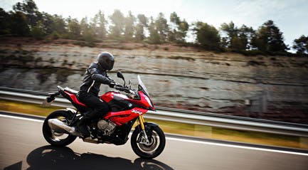 BMW S 1000 XR TRIPLE BLACK being ridden on the hill road