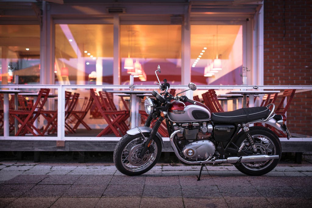 TRIUMPH BONNEVILLE T120 in cranberry red and aluminium silver colour, parked