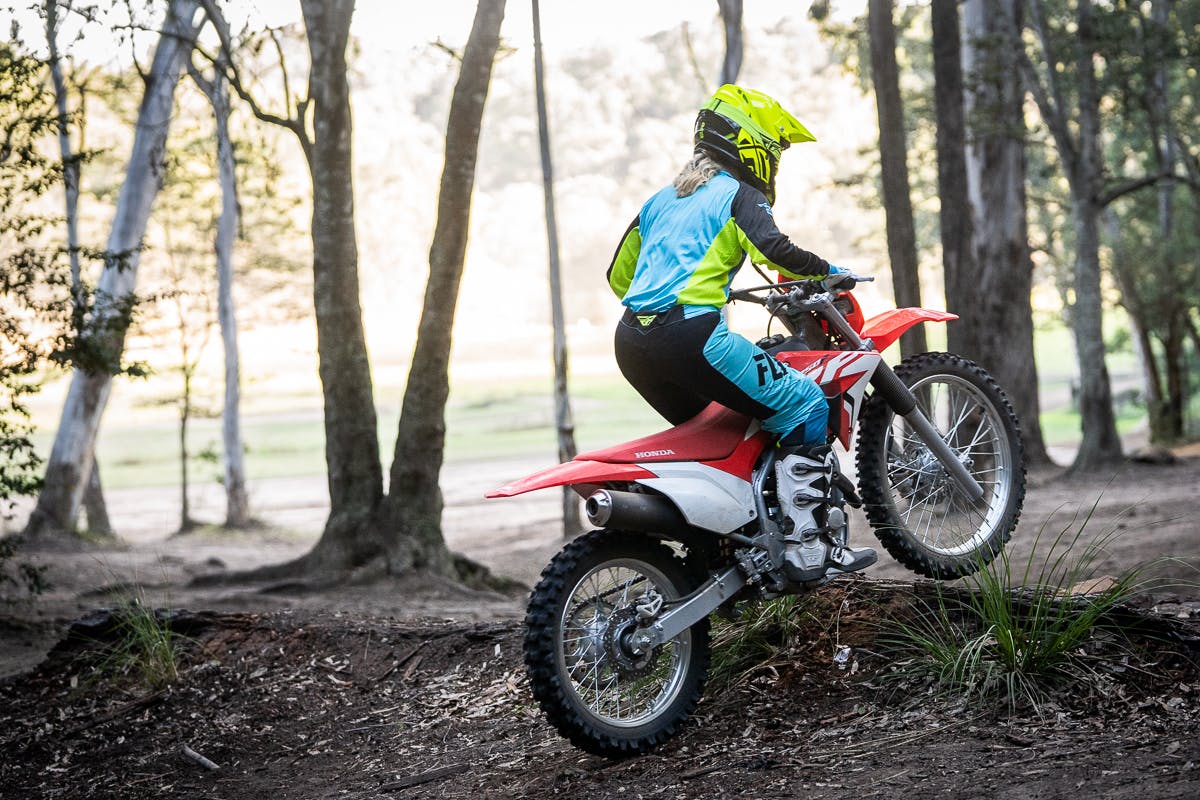 Honda CRF250F in extreme red colour being ridden on off road track