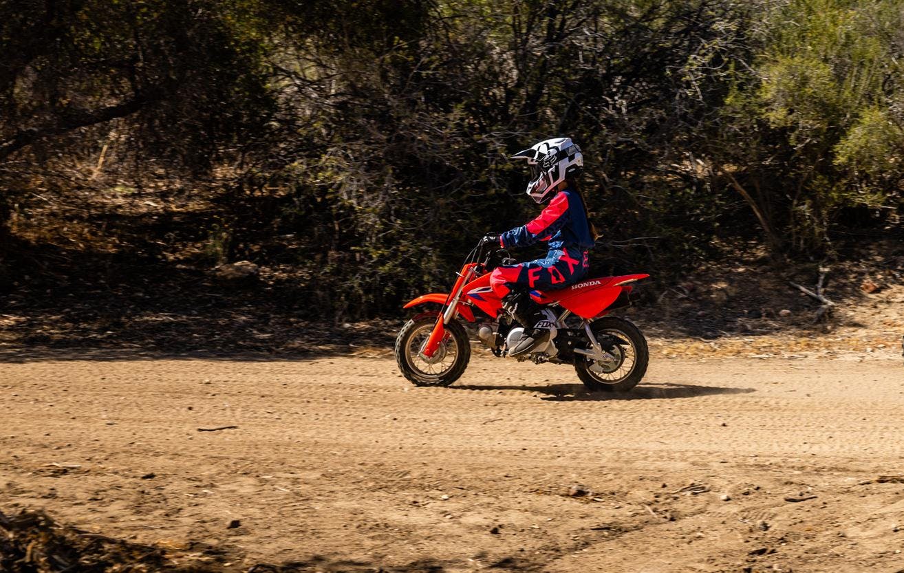 Honda CRF50F in extreme red colour on off road track
