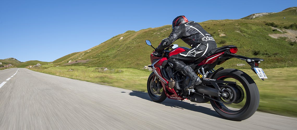 Honda CBR650R in grand prix red colour, being ridden on a race track