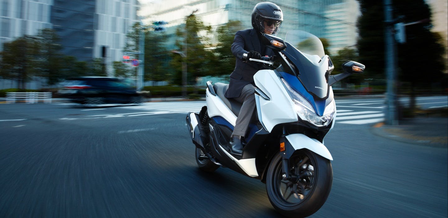 Honda Forza 300 in Pearl Horizon White colour being ridden on the road