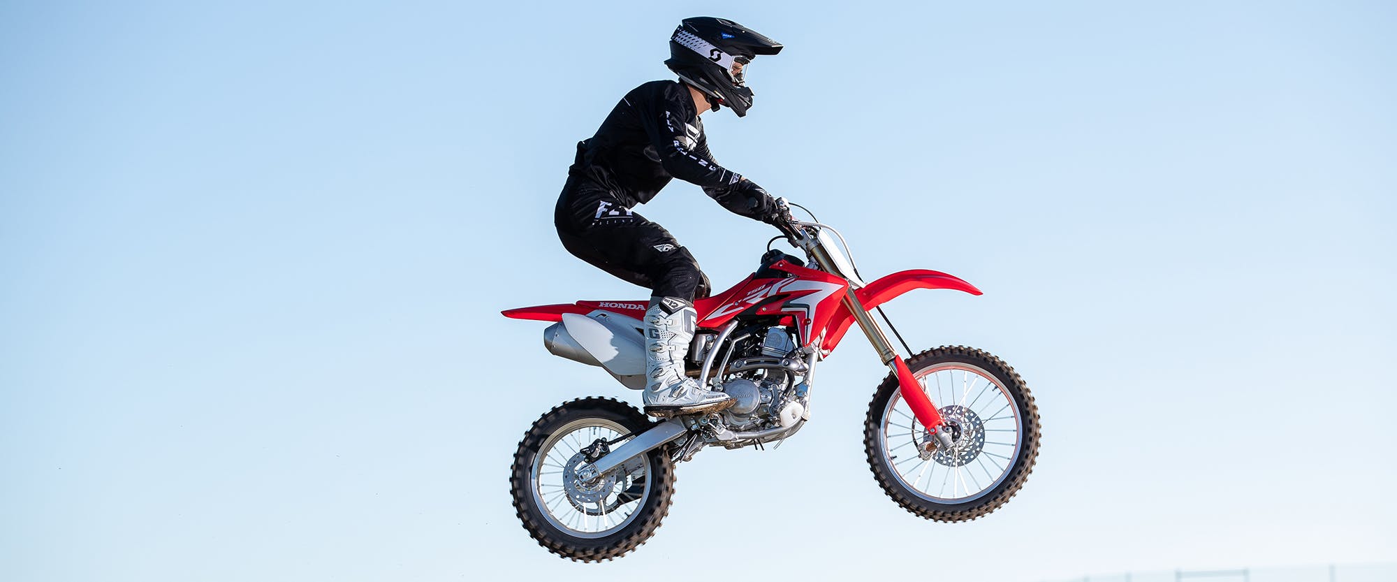 Honda CRF150R in extreme red doing air stunts