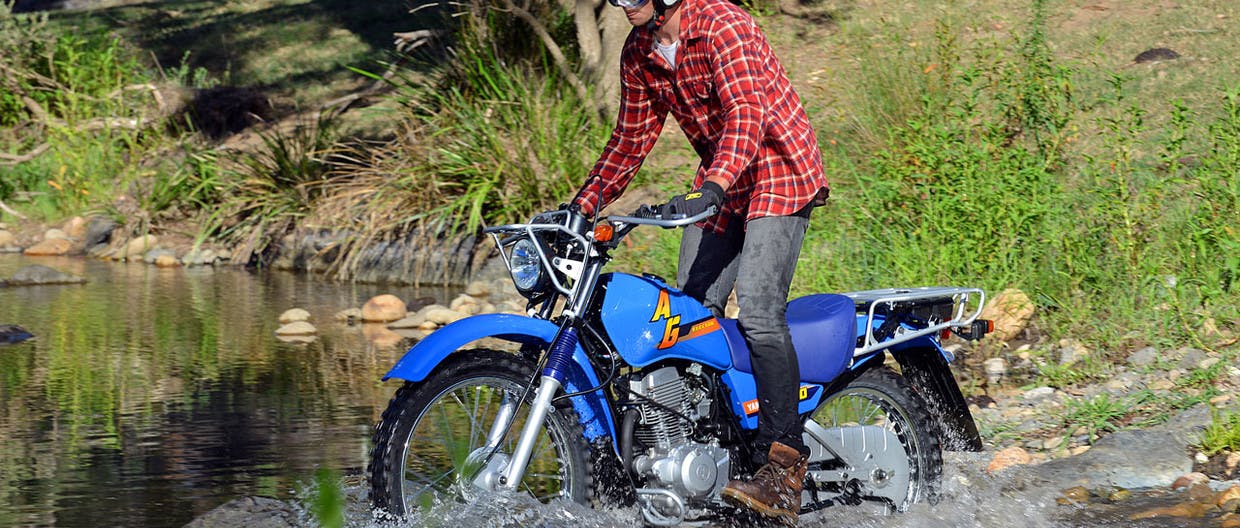 Yamaha AG200F in AG Blue colour crossing a creek