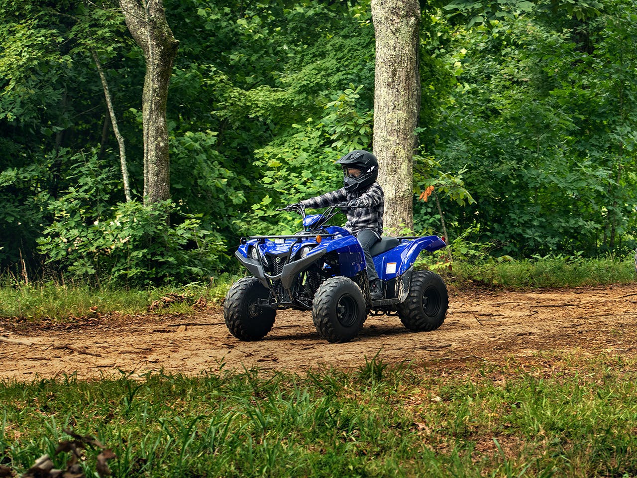 Yamaha Grizzly 90 in Steel Blue colour, being ridden off-track