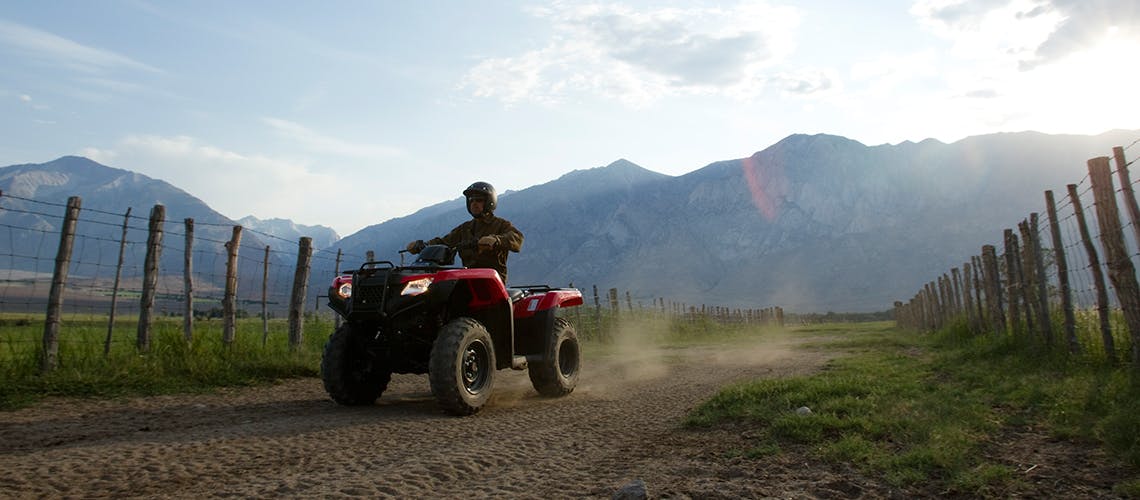 Honda TRX420TM1, being ridden on the farm