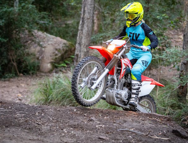 Honda CRF250F in extreme red colour being ridden on off road track