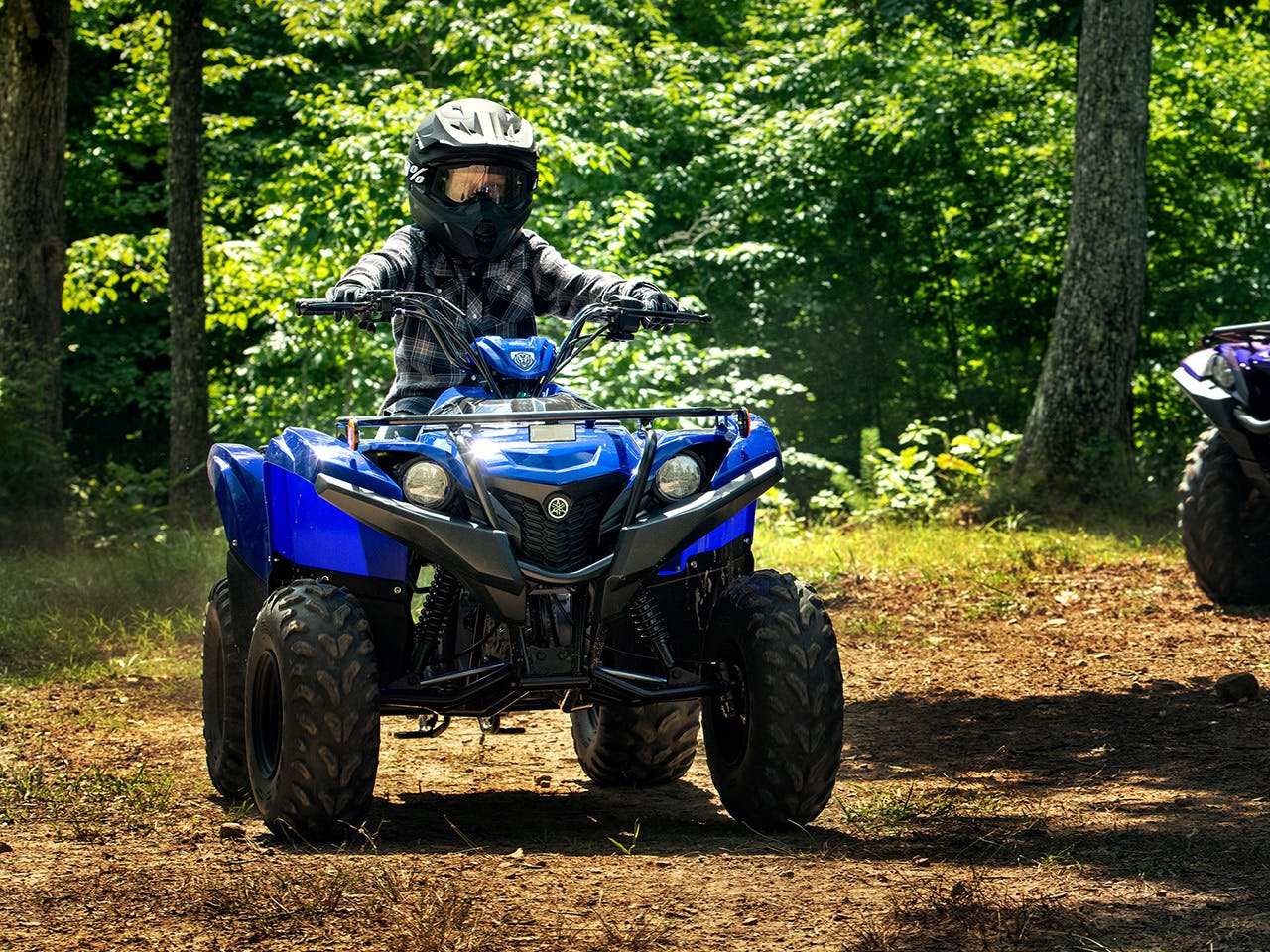 Yamaha Grizzly 90 in Steel Blue colour, being ridden off-track