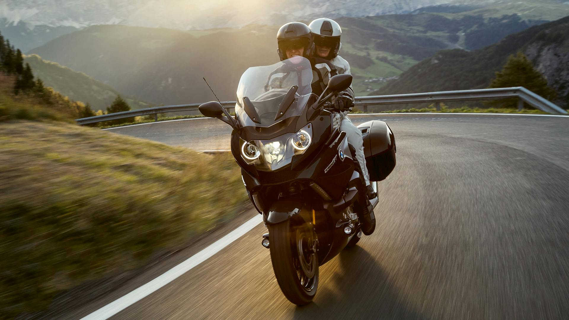 BMW K 1600 GT being ridden on the hill road with a passenger