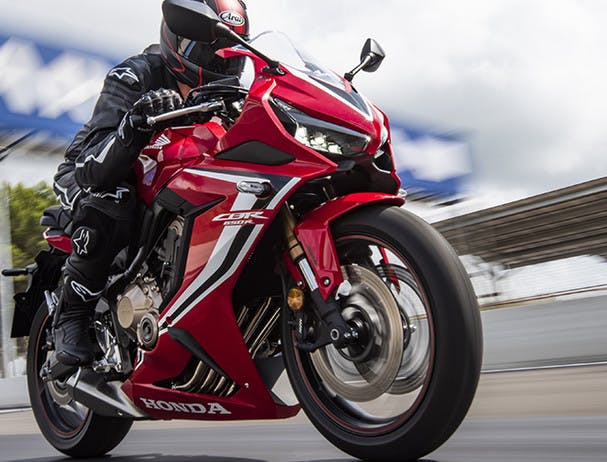 Honda CBR650R in grand prix red colour, being ridden on a race track
