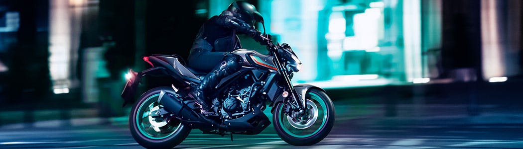Yamaha MT-03 in cyan storm color, on the road.