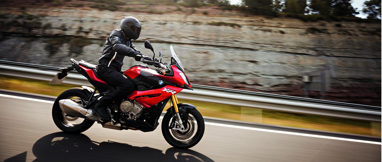 BMW S 1000 XR TRIPLE BLACK being ridden on the hill road